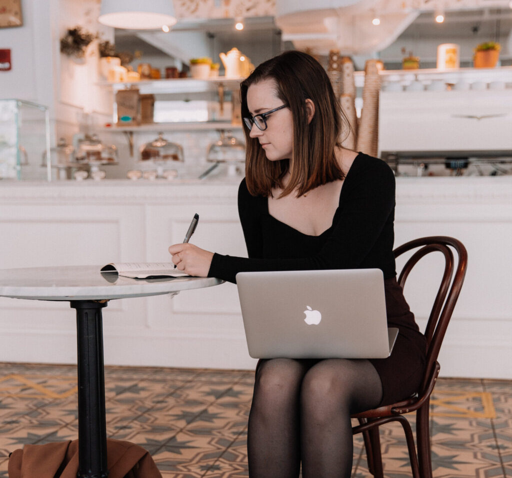 Rebecca with a laptop sitting at a table
